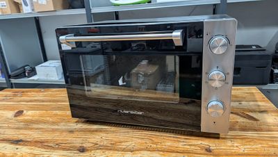 an image of a toaster oven sitting on a wooden table