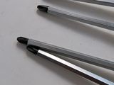several pens are lined up on a white surface with a blue marker