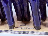a blue vase that has a group of cats on it
