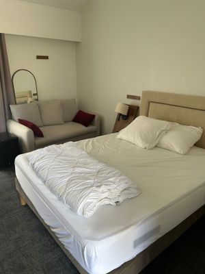 un lit avec des draps et des oreillers blancs dans une chambre