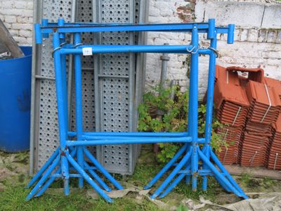 un cadre bleu posé par terre à côté d'un bâtiment