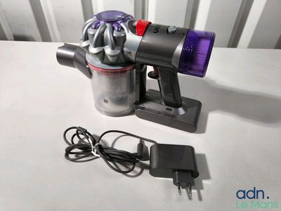 un aspirateur posé sur une table à côté d'un chargeur