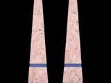 pair of pink marble obelis on black background with reflection