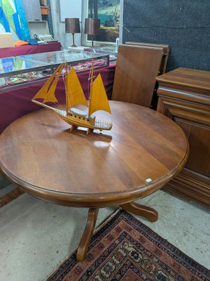 une petite table sur laquelle se trouve un voilier, dans une pièce