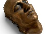sculpture en bronze représentant la tête d'un homme sur un fond blanc