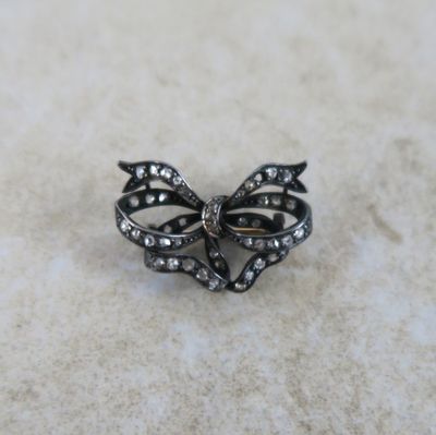 une image représentant une broche en forme de nœud en diamant, en noir et blanc