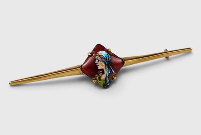gold - plated hair pin with a woman ' s face painted on it