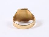 an image of a gold signet ring on a white surface