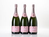 three bottles of champagne sitting on top of a white table