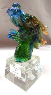 une sculpture en verre représentant un oiseau perché sur une branche d'arbre