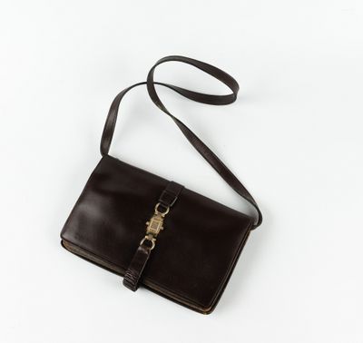 un porte-monnaie en cuir marron muni d'un fermoir métallique, sur fond blanc