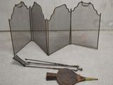 un petit tamis métallique, une spatule en bois et d'autres objets posés par terre