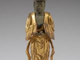 a gold statue of a person with a crown on top of his head