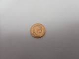 a close up of a gold coin on a white surface