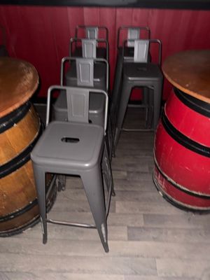 plusieurs tabourets et une table dans une pièce dont l'un des murs est rouge