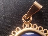 a gold pendant with a blue stone on it