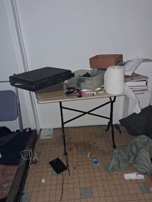 une table sur laquelle est posé un ordinateur portable, dans un coin de la pièce