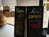 Des boîtes de café sont posées sur un comptoir devant une fenêtre