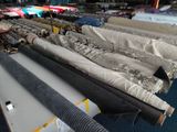 many rolls of fabric sitting on a table in a room