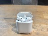 an apple airpods are sitting on a table in front of a clear box
