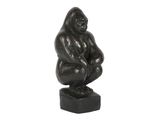 une statue représentant un gorille assis sur un bloc
