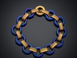 a close up of a blue and gold bracelet on a black surface