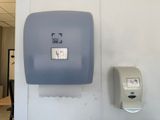 a blue paper towel dispenser hanging on the wall