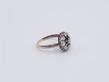 a close up of a gold and diamond ring on a white surface