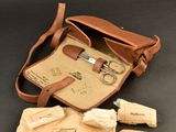 a brown leather bag with a pair of scissors and other items in it