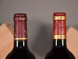 two bottles of wine sitting next to each other on a table
