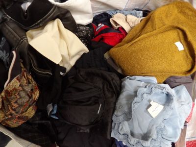 a suitcase full of clothes and a handbag on the floor