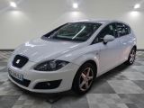 La voiture blanche est garée sur le sol à damier de la pièce.