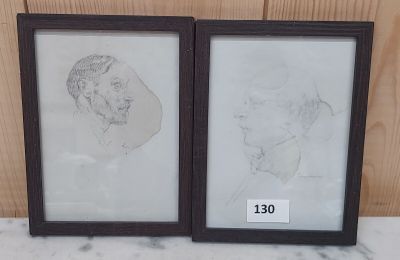 Deux dessins encadrés représentant un homme et une femme sont posés sur une table.
