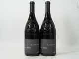 deux bouteilles de vin posées sur une table blanche