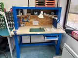 un établi bleu sur lequel se trouvent un bureau et une lampe
