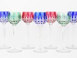 six wine glasses are lined up in a row on a white surface