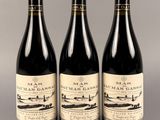 trois bouteilles de vin posées sur une table l'une à côté de l'autre