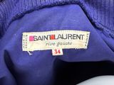 the label of a saint laurent sweater is on the back of a white toilet