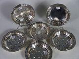 six silverplated dishes on a white surface