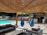 an outdoor living area with a pool and a hammock