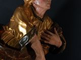 gold statue of a man holding a guitar in his right hand