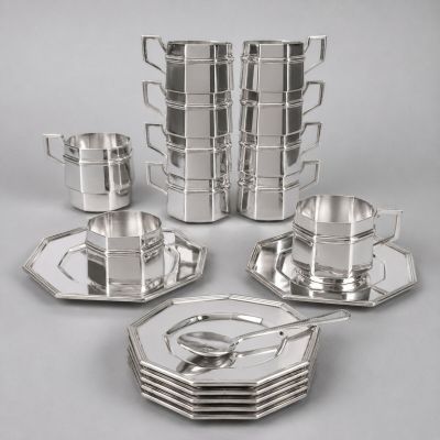 a group of silver plated dishes and cups on a table