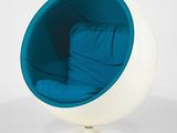 fauteuil sphérique bleu et blanc avec un coussin, posé sur un piètement blanc