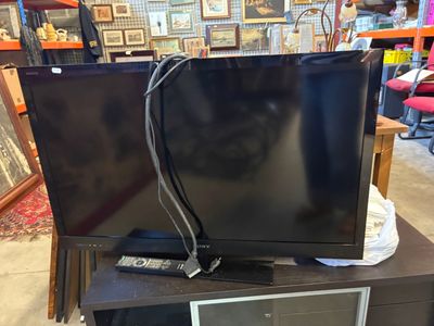 two televisions sitting on top of a table in a store