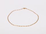 a gold chain bracelet with a tiny bead on a white background