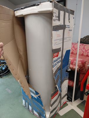 un homme debout à côté d'un carton contenant des toilettes