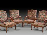 un ensemble de quatre fauteuils de style Louis II, dont les assises sont recouvertes d'un tissu à motifs floraux