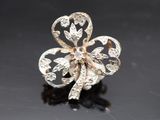 une photo d'une broche en forme de trèfle en or et diamants