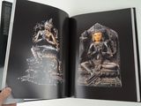 a person holding a book with a picture of a statue on it