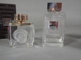 two bottles of perfume with a picture of a woman in the background